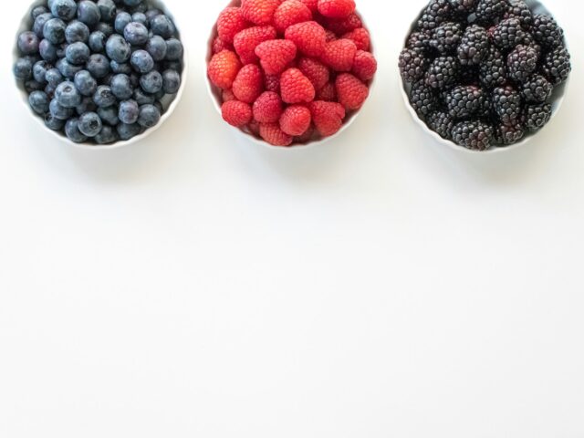 black and red berries on white surface